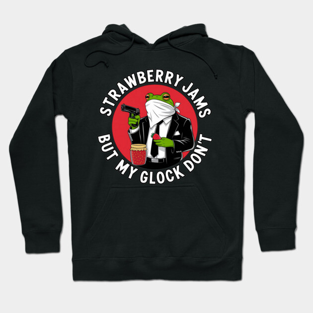 Black hoodie with humorous frog graphic, text "Strawberry Jams But My Glock Don't", casual streetwear style.