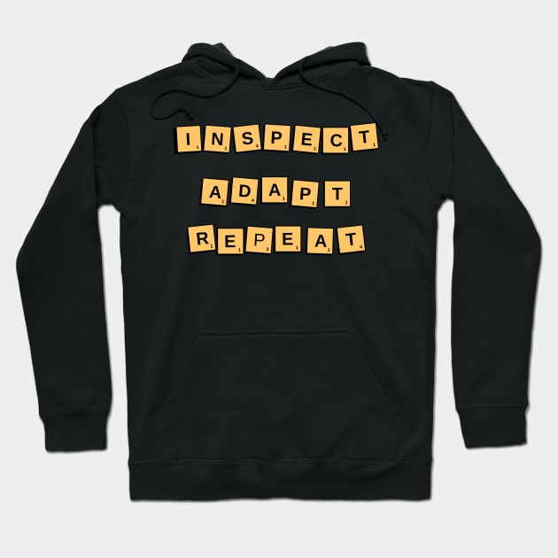 Black hoodie with yellow Scrabble-style tiles spelling "Inspect Adapt Repeat," ideal for casual wear.