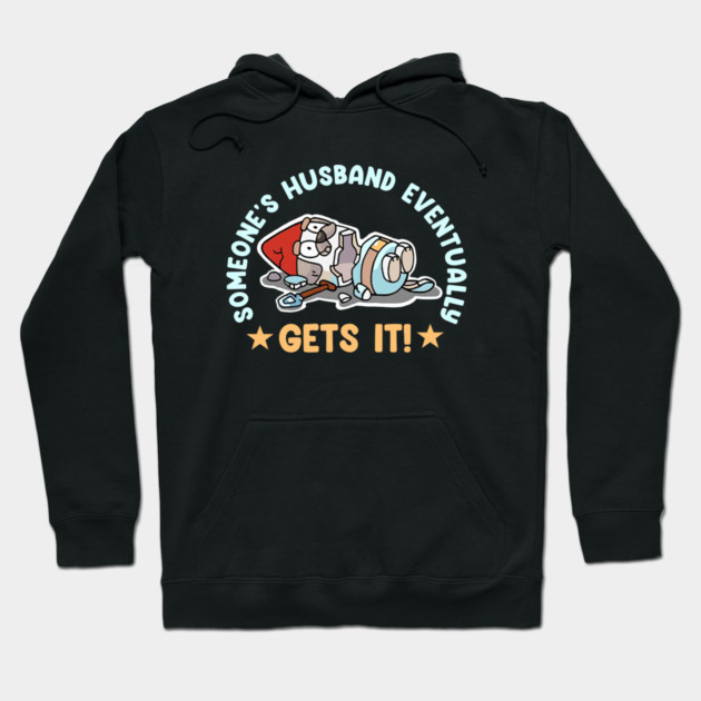 Black hoodie with humorous graphic and text, "Someone's Husband Eventually Gets It!" Cozy cotton material, casual style.
