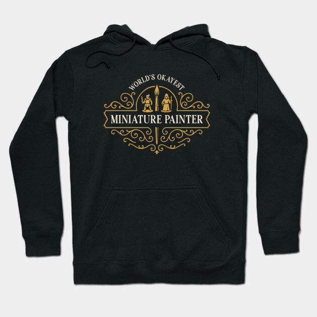 Black hoodie with "World's Okayest Miniature Painter" gold print, casual style, perfect for comfortable wear.