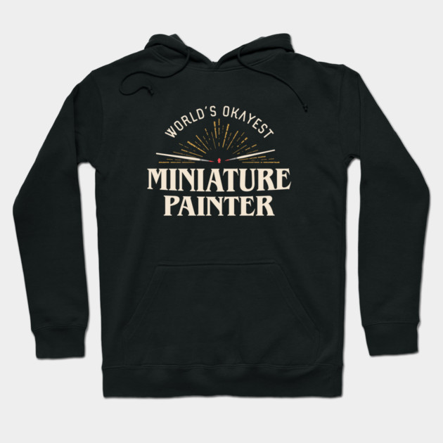 Black hoodie with "World's Okayest Miniature Painter" print, casual style, cotton blend, perfect for hobbyists.