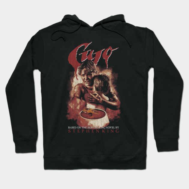 Black "Cujo" graphic hoodie featuring vintage horror design, inspired by classic novel. Cozy, stylish, cotton blend.