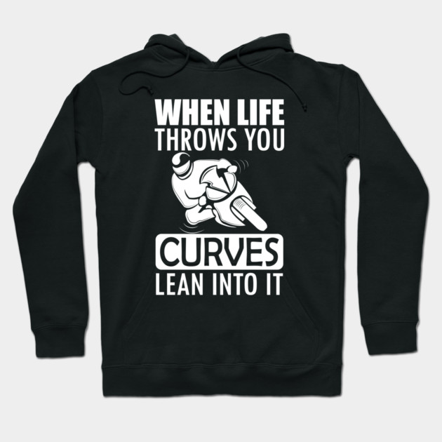 Black hoodie with white text "When Life Throws You Curves, Lean Into It," featuring a motorcycle graphic. Casual wear.